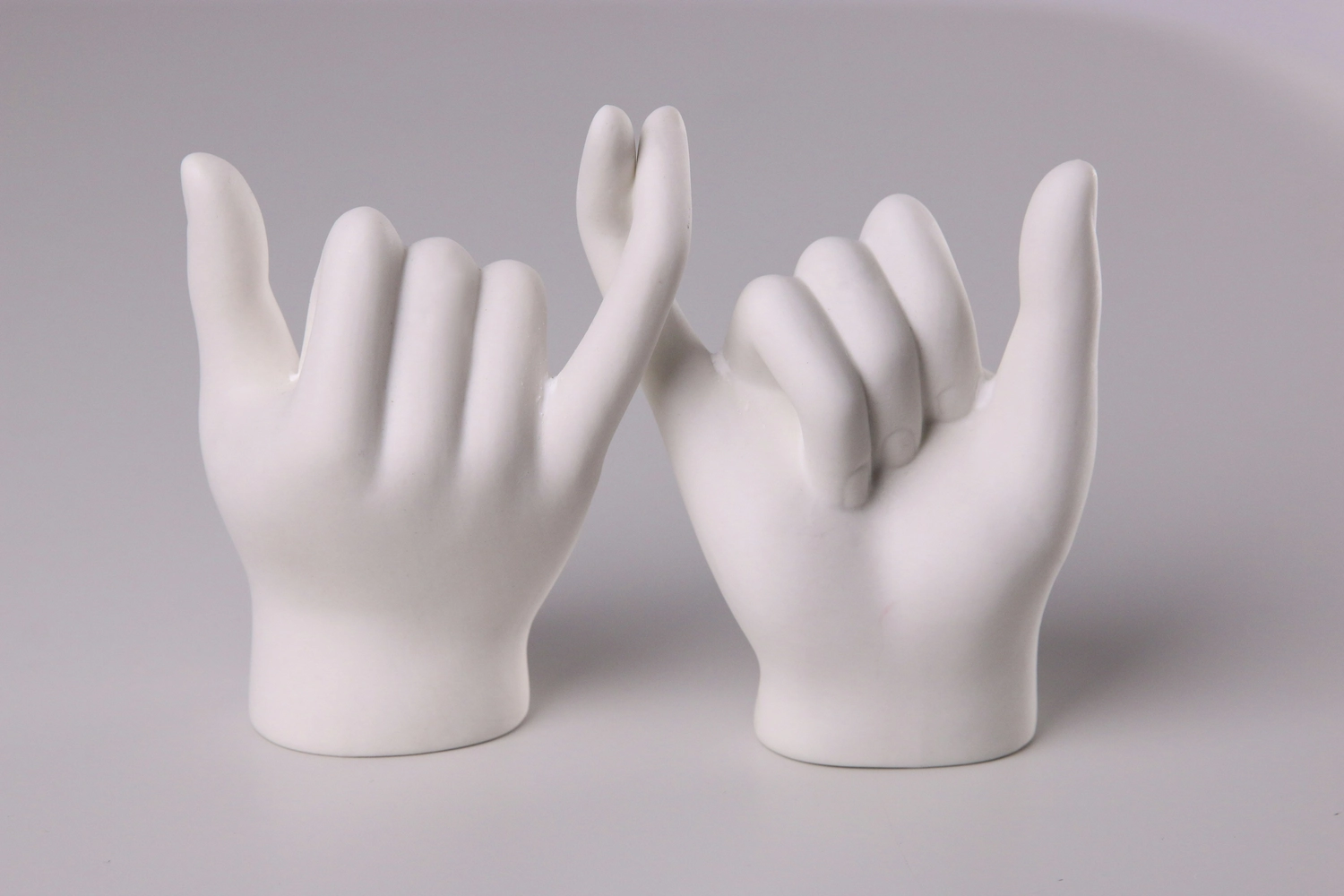 Zwei Porzellanhände reichen einander den kleinen Finger und symbolisieren damit gegenseitguie Unterstützung. Das ist ein Symbol dafür, dass man mit ME/CFS leben lernen kann.