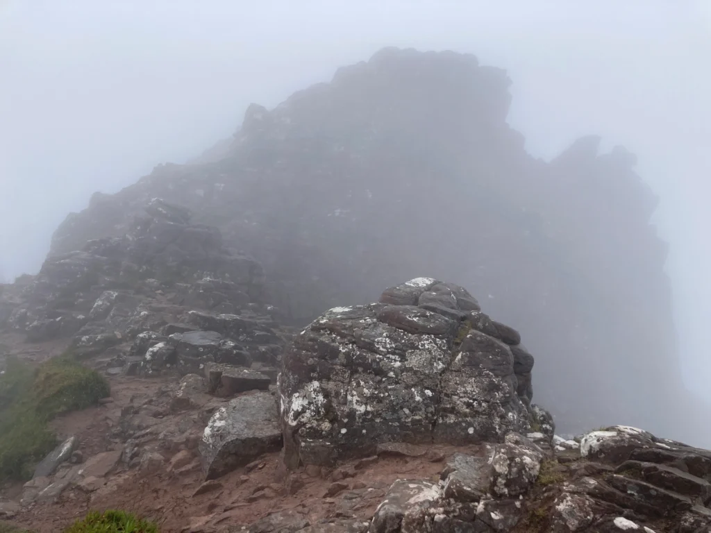 Felsen am Berggrat im Nebel, Abgründe auf den Seiten wegen des Nebels nur zu erahnen